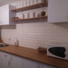 3D tapete bela cigla postavljena u kuhinji na zidu između površine radnog stola i visećih elemanata.