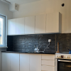 3D tapete model "Dekorativni kamen" u sivoj boji prikazan postavljen u kuhinji na zidu između radnog stola i visećih elemenata kuhinje.